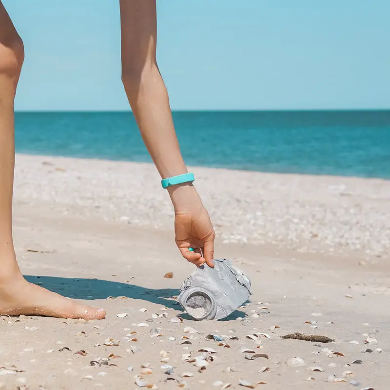 Woman Picking Up Trash at a Beach