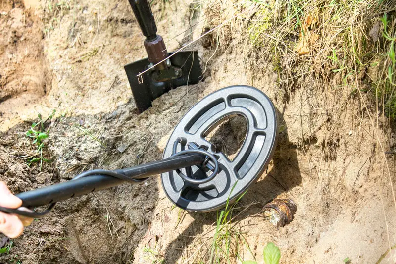 Man on beach metal detecting.