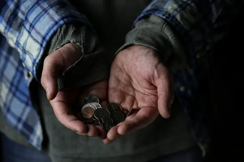 A man holding a handful of coins