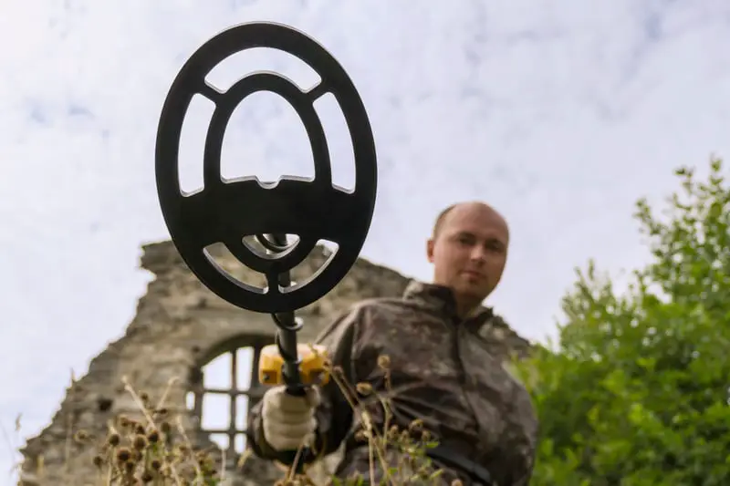 Man holding a metal detector.