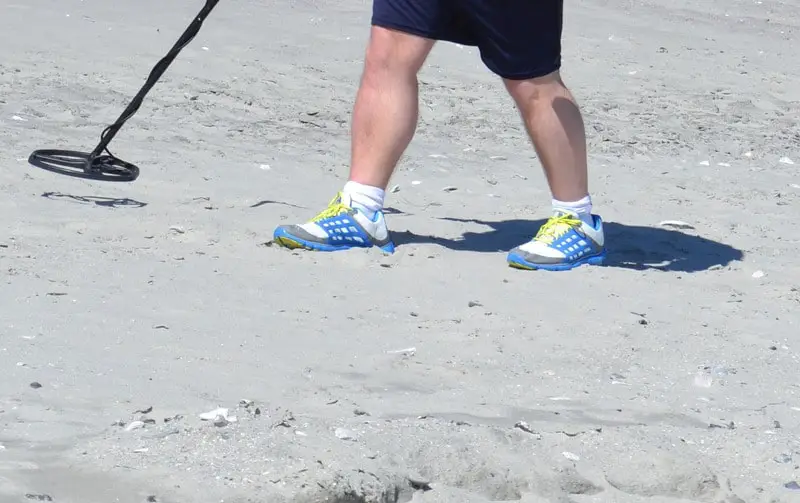 Metal Detecting on a Sandy Beach in the summer.