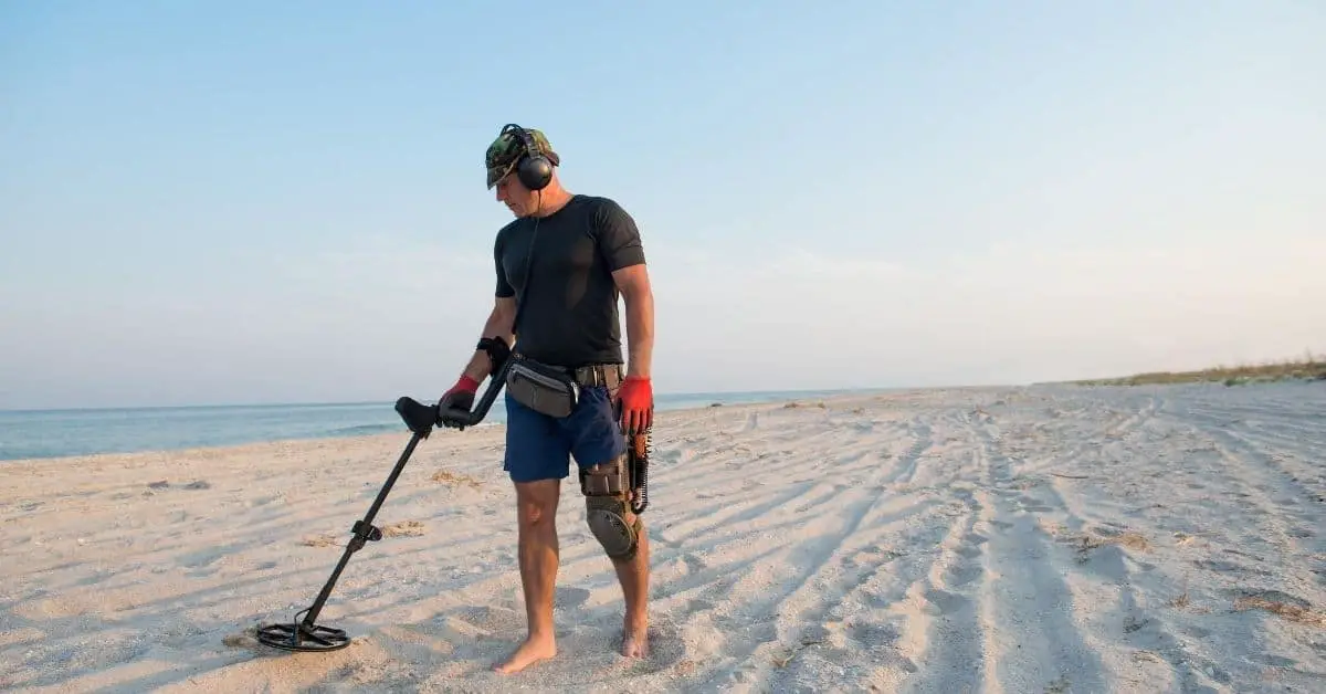 Man Metal Detecting on the beach.