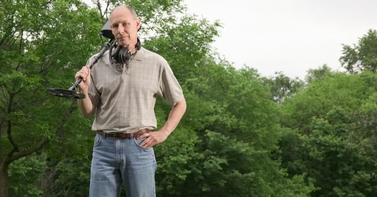 Man holding a metal detector over his shoulder